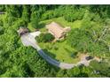 Aerial shot of a home with a long driveway and detached garage surrounded by mature trees and landscaping at 3956 Tell Sw Rd, Atlanta, GA 30331