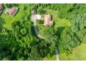 Aerial view of a one-story house surrounded by dense trees, with a long driveway and small outbuilding at 3956 Tell Sw Rd, Atlanta, GA 30331