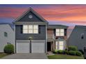 Charming two-story home featuring a combination of brick and blue siding, plus a two-car garage and manicured landscaping at 535 Watercress Dr, Woodstock, GA 30188