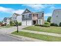 Beautiful home with a two-car garage, green lawn, and manicured shrubs at 535 Watercress Dr, Woodstock, GA 30188