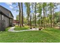 Spacious backyard with a fire pit area and lush greenery provides a serene retreat and entertaining space at 5759 Albans Way, Lithonia, GA 30058