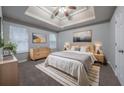 Spacious main bedroom with large bed, modern decor, and a tray ceiling at 5779 Wellborn Creek Dr, Lithonia, GA 30058