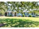 Inviting home exterior with a lush green lawn and classic architectural details framed by mature shade trees at , Social Circle, GA 30025
