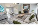 Open-concept living room with stone fireplace, modern furniture, and hardwood-style flooring at 1194 Clichy Ct, Marietta, GA 30066