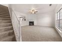 Spacious living room featuring plush carpeting, a classic fireplace, and a large window at 2736 Parkway Trl, Lithonia, GA 30058