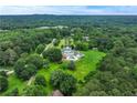 An expansive estate home is pictured in this aerial view that shows a swimming pool and sprawling wooded acreage at 2595 Ross Rd, Snellville, GA 30039
