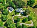 Expansive aerial view of estate with multiple buildings, a serene pond, and lush greenery at 228 Indian Creek Rd, Locust Grove, GA 30248