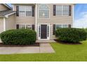 Inviting home entrance with a decorative door, complemented by manicured shrubs and green grass at 165 Heaton Place Trl, Covington, GA 30016