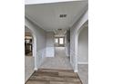 Inviting entryway featuring arched doorways, neutral paint, and new flooring at 165 Heaton Place Trl, Covington, GA 30016
