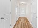Hallway with wood-look floors, white doors, and a view to the exterior at 1931 Old Dogwood, Jonesboro, GA 30238