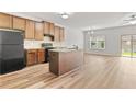 Open kitchen with wood cabinets, island, black appliances and adjacent dining area at 1931 Old Dogwood, Jonesboro, GA 30238
