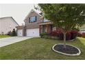 Beautifully landscaped front yard with mature trees, green grass, and a well-maintained lawn, complements the brick home at 2029 Havenhurst Way, Auburn, GA 30011