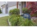 Close up on well landscaped yard with flowers and shrubs, and a view of the home's exterior and two car garage at 2029 Havenhurst Way, Auburn, GA 30011