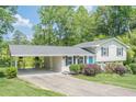 Charming split-level home featuring a manicured lawn, bright blue door, and covered carport, inviting you to call it home at 205 Plantation Sw Rd, Smyrna, GA 30082