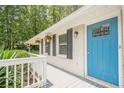 Close up of a charming front porch with a bright blue front door, offering a warm and welcoming curb appeal at 205 Plantation Sw Rd, Smyrna, GA 30082
