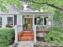 Inviting front porch with brick steps, white railing, and hanging plants, creating a cozy outdoor space at 646 Darlington Ne Cir, Atlanta, GA 30305
