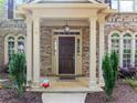 Inviting front porch with classic columns and decorative planters leading to a charming entrance at 1450 Liberty Ln, Cumming, GA 30040