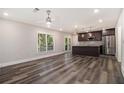 Open-concept living room and kitchen with stainless steel appliances and wood flooring at 1749 W Caribaea Se Trl, Atlanta, GA 30316