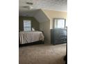 A cozy bedroom with carpet, a window with blinds, and dark wood furniture at 222 Yardsley Dr, Mcdonough, GA 30253