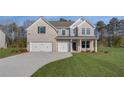 Charming two-story home boasts a three-car garage and lush green lawn under a clear blue sky at 112 Felicity Pike, Locust Grove, GA 30248
