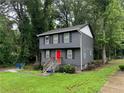 Lovely two-story home with a modern gray exterior, black shutters, and a striking red front door at 2351 Carver Nw Dr, Atlanta, GA 30314