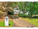 Charming home with a long driveway, well-maintained landscaping, and mature trees surrounding the property at 3185 Country Club Nw Ct, Kennesaw, GA 30144