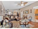 Cozy living room featuring hardwood floors, a ceiling fan, and comfortable seating at 3902 Cedarwoods Way, Lawrenceville, GA 30044