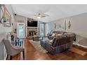 Comfortable living room featuring hardwood floors, a ceiling fan, and a stone fireplace at 3902 Cedarwoods Way, Lawrenceville, GA 30044