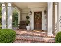 Inviting front porch with brick steps, a wooden bench, and a decorative wreath on the door at 54 Camden Ne Rd, Atlanta, GA 30309