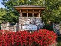 Stone entrance to Great Sky neighborhood with beautiful landscaping and manicured flower beds at 1045 Pine Bark Ln, Canton, GA 30114