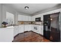 Functional kitchen featuring white cabinets, dark appliances, updated counter tops and hardwood floors at 335 Lee Miller Ct, Suwanee, GA 30024