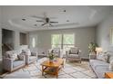 A bright living room with ample seating, a tray ceiling, and natural light from the large windows at 2475 Harvel Nw Dr, Atlanta, GA 30318