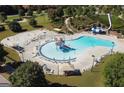 Aerial view of the community pool with a splash pad, water slide, lounging area, and ample seating for residents at 81 Richmond Way, Villa Rica, GA 30180