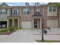 Three-story townhome with brick facade, attached garage, and manicured front yard at 1649 Southgate Mill Nw Dr, Duluth, GA 30096