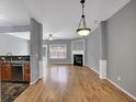 Open-concept living room with hardwood floors, a fireplace, and views to the kitchen at 1649 Southgate Mill Nw Dr, Duluth, GA 30096