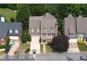 Aerial view of a brick home with a two-car garage, mature landscaping, and nearby homes at 1121 Vinings Grove Se Way, Smyrna, GA 30082
