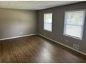 Living room features sleek laminate flooring and bright natural light from dual windows at 8415 Magnolia Dr, Jonesboro, GA 30238