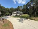 Home on a sprawling lot featuring a long driveway and a charming front porch, embraced by verdant landscaping at 190 Paul Aiken Rd, Dallas, GA 30157