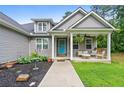 Close-up of a cozy front porch with stylish seating and decorative hanging plants at 190 Paul Aiken Rd, Dallas, GA 30157
