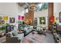 Bright open-concept living space with exposed brick, modern lighting, and views of the greenery outside at 195 Arizona Ne Ave # 197, Atlanta, GA 30307