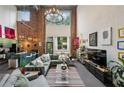 Spacious living room with high ceilings, exposed brick, modern lighting, and open floor plan to dining and kitchen at 195 Arizona Ne Ave # 197, Atlanta, GA 30307