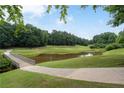 Scenic golf course view with pond, bridge, and lush green trees in a beautiful landscape at 3525 Stone Cliff Way, Woodstock, GA 30189