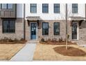 A view of the townhome entrance with a blue door and manicured front yard at 4231 Millcroft Pl # 207, Buford, GA 30518