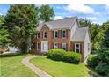 Beautiful brick home featuring traditional architecture and a lush green lawn at 2196 Kildare Nw Way, Kennesaw, GA 30152