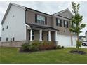 Two-story home with a brick front, black shutters, a covered porch, and a well-maintained lawn at 3378 English Elm Way, Loganville, GA 30052
