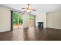 Bright living room features a fireplace, wood floors, ceiling fan, and access to the outdoor deck at 262 Bell Grove Ln, Suwanee, GA 30024