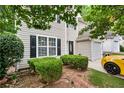 This home features a tan exterior, black shutters, and a beautifully landscaped yard with a sporty yellow car at 248 Springbottom Dr, Lawrenceville, GA 30046