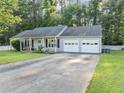 Single-story home featuring an attached two-car garage, white picket fence, and an expansive front lawn at 600 River Bend Sw Cir, Smyrna, GA 30082