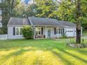 Charming single-story home with a well-manicured lawn and an inviting front porch with wicker seating at 600 River Bend Sw Cir, Smyrna, GA 30082