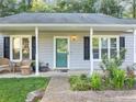 Close-up of the front entrance with quaint seating, decorative plants, and a brick walkway at 600 River Bend Sw Cir, Smyrna, GA 30082
